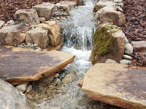 pondless waterfall with large bordering rocks and cascading steps