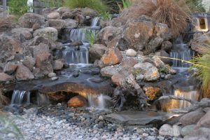 Disappearing or pondless waterfall with multiple tiers and rock bed